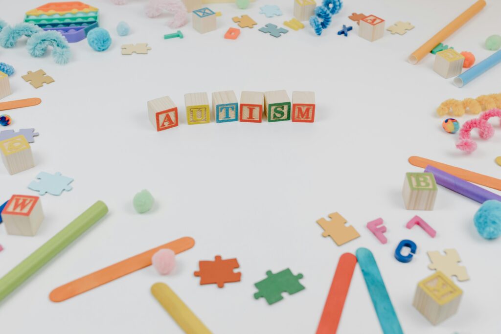 Colorful toys and puzzle pieces symbolizing autism awareness on a white background.